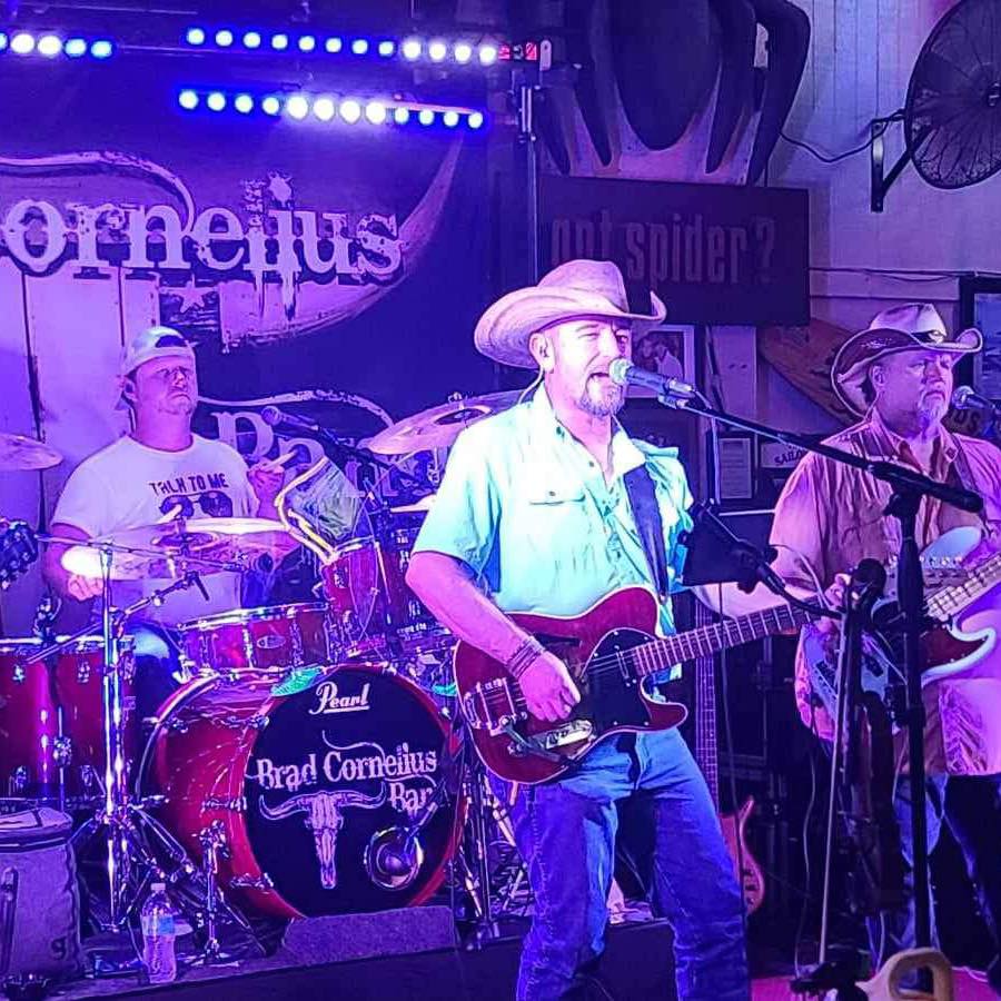 A man in cowboy hat playing guitar on stage.