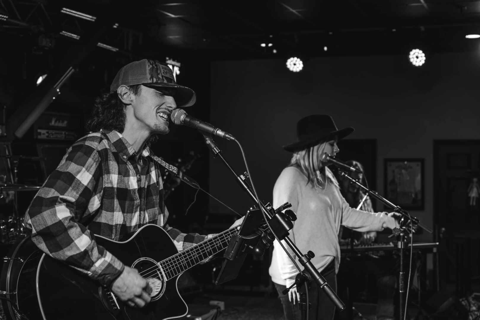 Two people are playing guitar and singing.