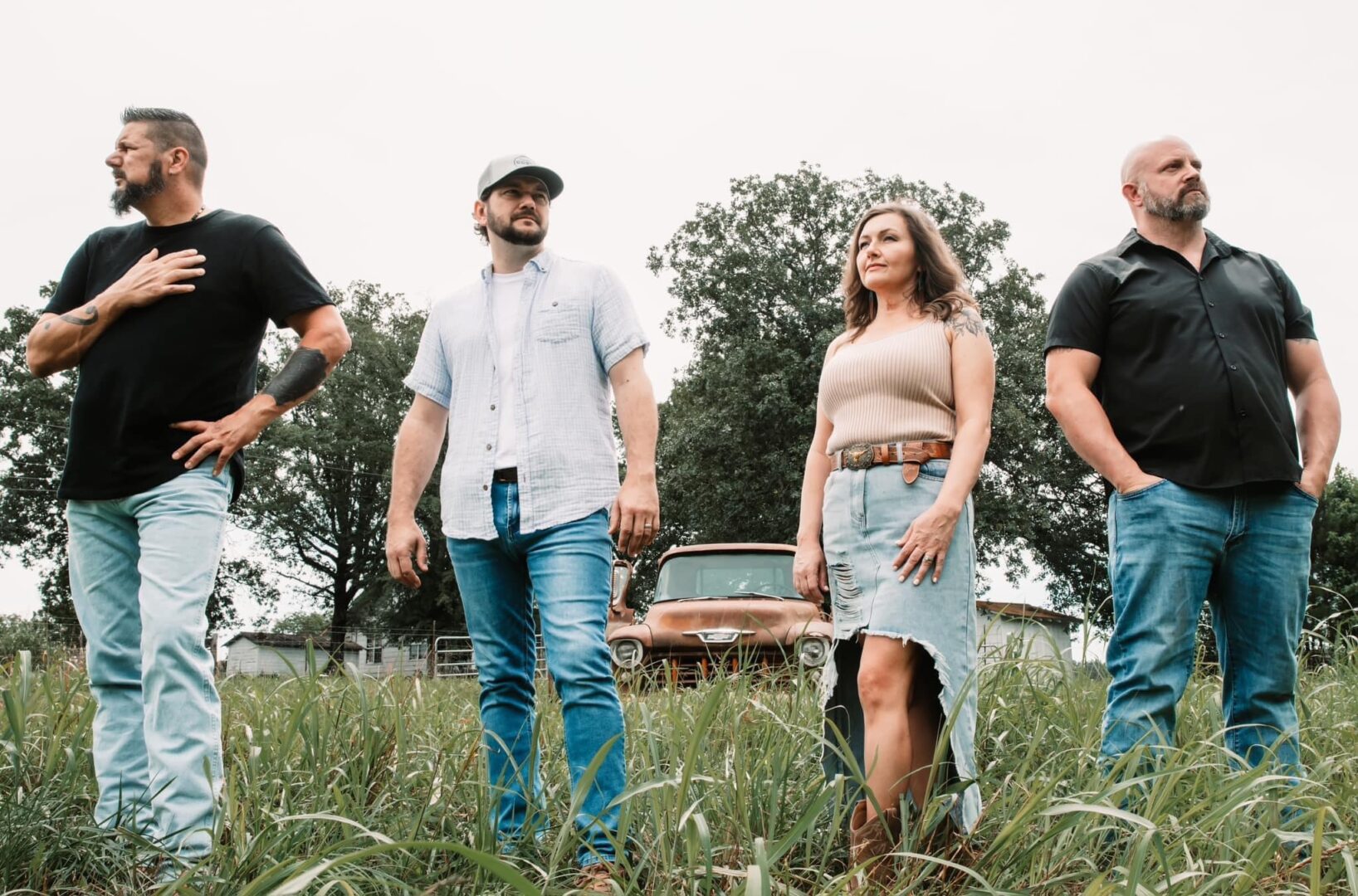 A group of people standing in the grass.