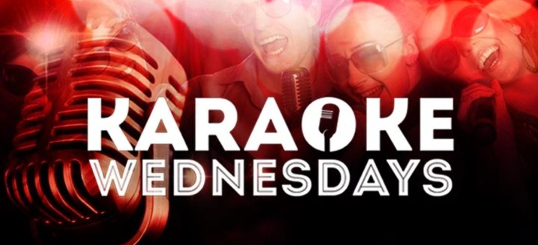 A microphone and two men singing in front of the words karaoke wednesday.